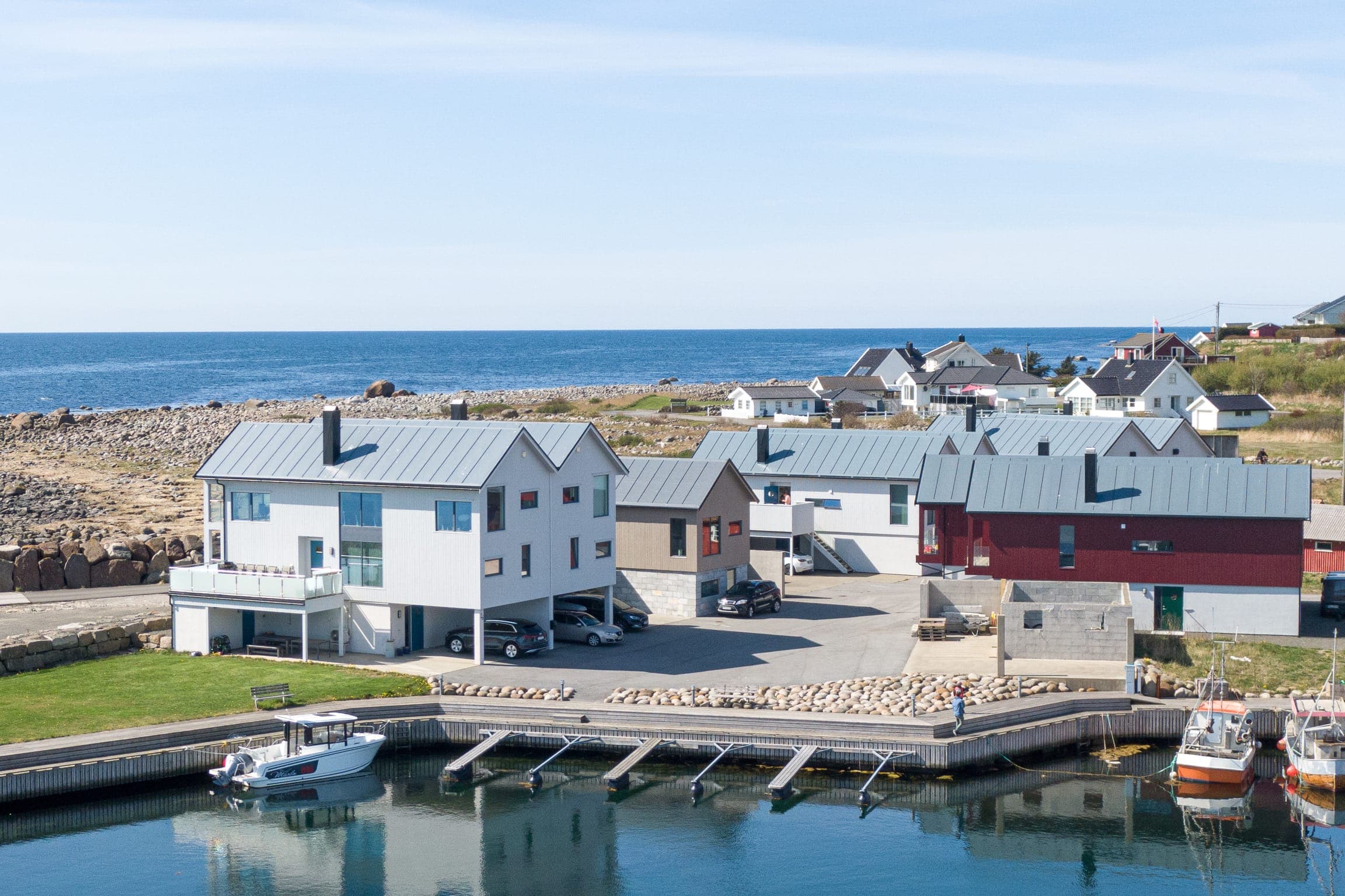 Holiday homes at Borhaug harbour on Lista, with the open sea behind