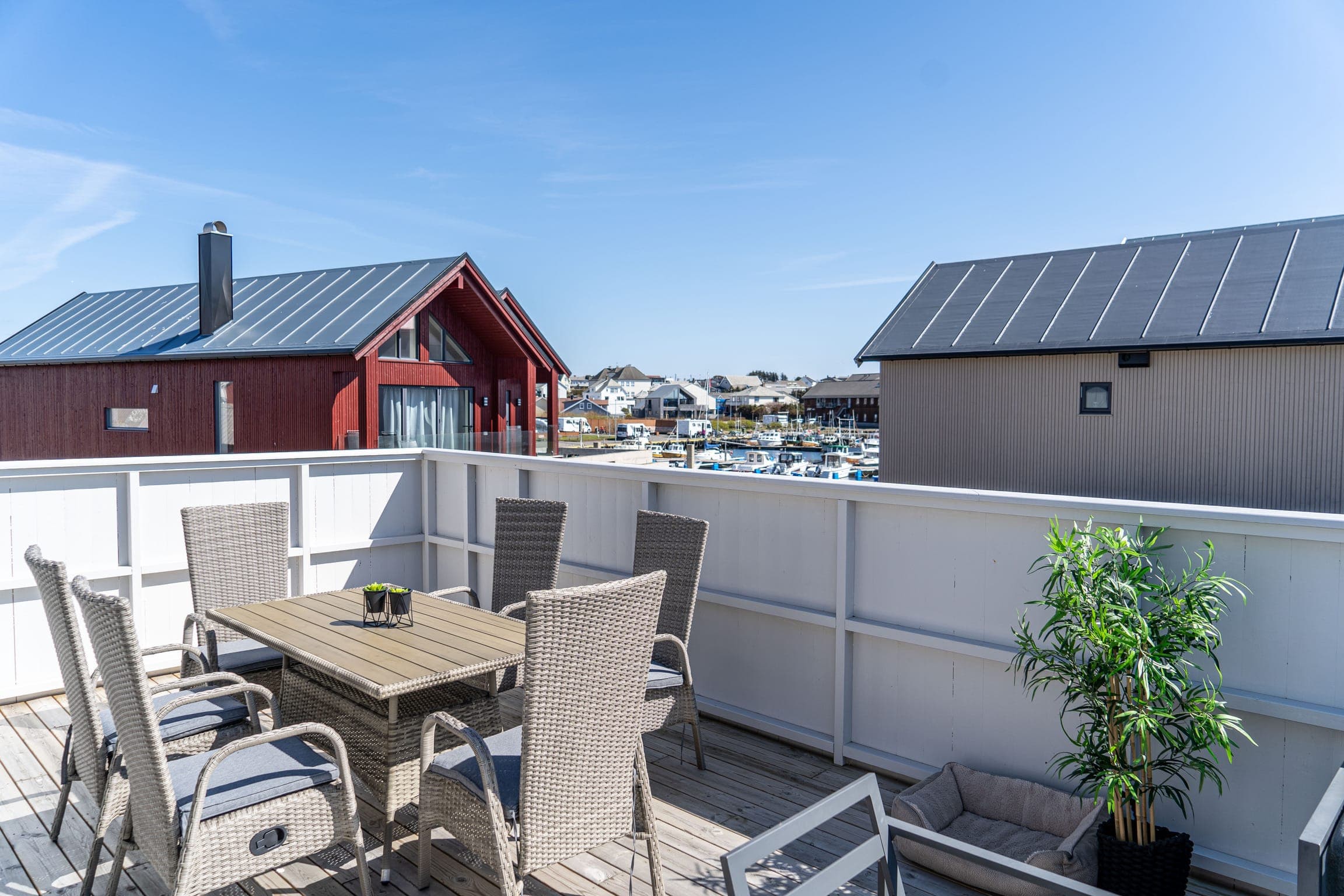 Terrasse mit großem Esstisch über dem Hafen von Borhaug auf Lista in Südnorwegen
